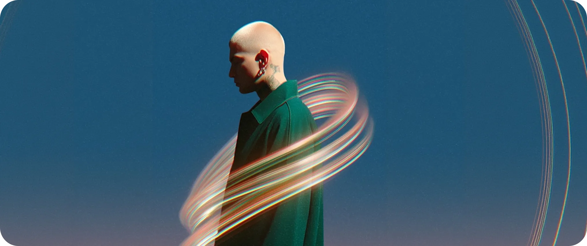 Profile of a bald person with tattoos and earrings wearing a dark green coat, surrounded by swirling light trails against a blue background.